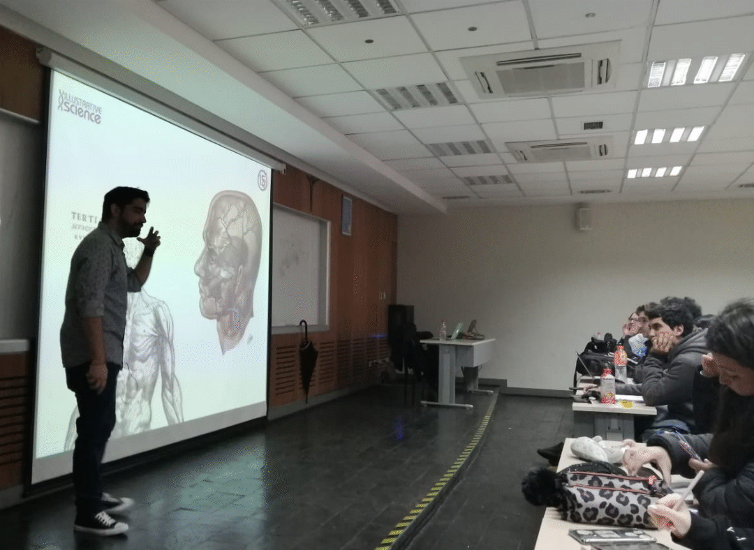 Felipe Serrano en sala universitaria con ilustración científica proyectada